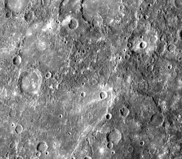 This double ring basin top center of image was photographed during NASA Mariner 10 second encounter and shows two craters about 30 km in diameter which have been engulfed by smooth plains on the floor of the inner ring. 