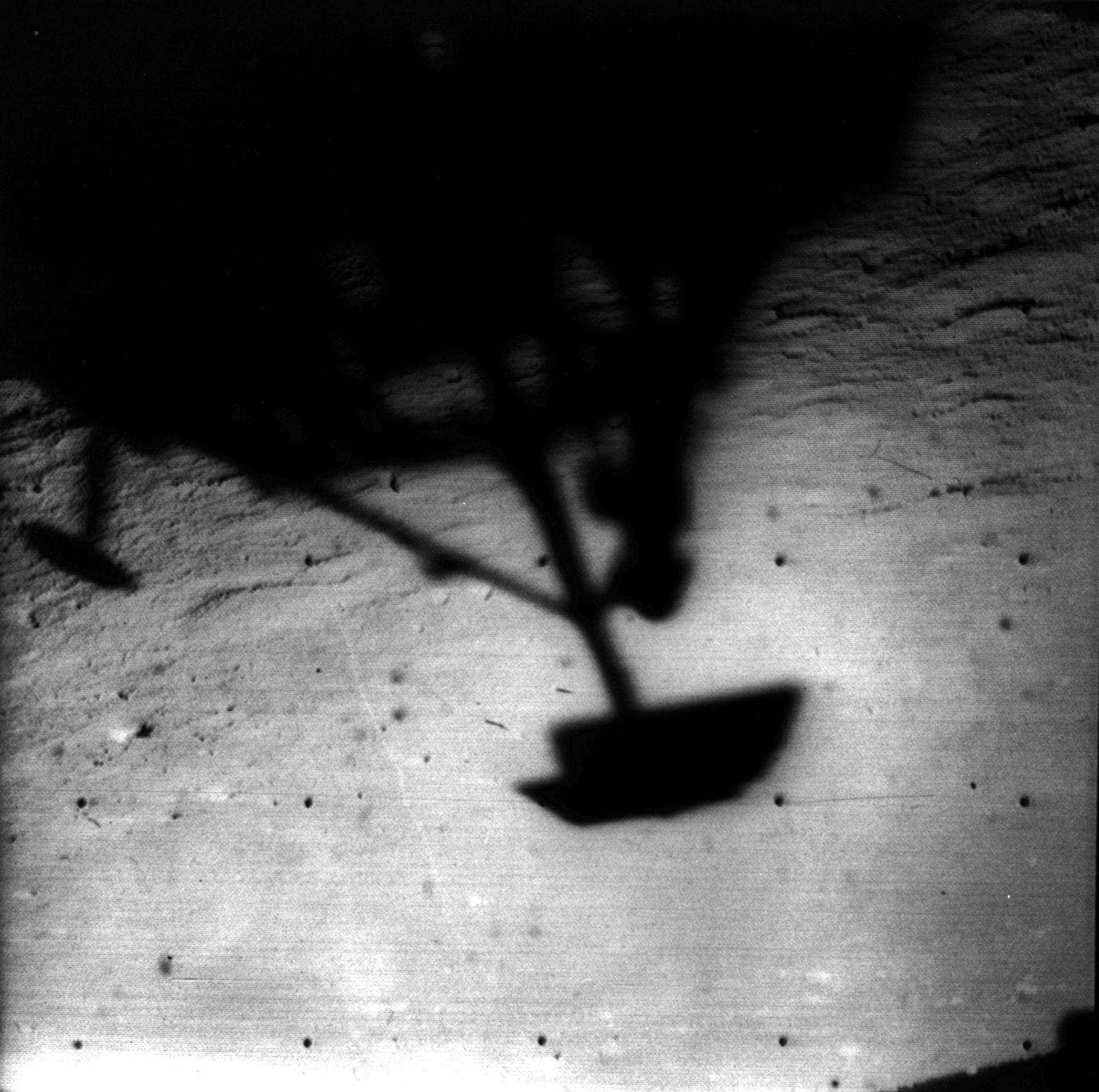 Image of Surveyor 1 shadow against the lunar surface in the late lunar afternoon, with the horizon at the upper right. Surveyor 1, the first of the Surveyor missions to make a successful soft landing, proved the spacecraft design and landing technique