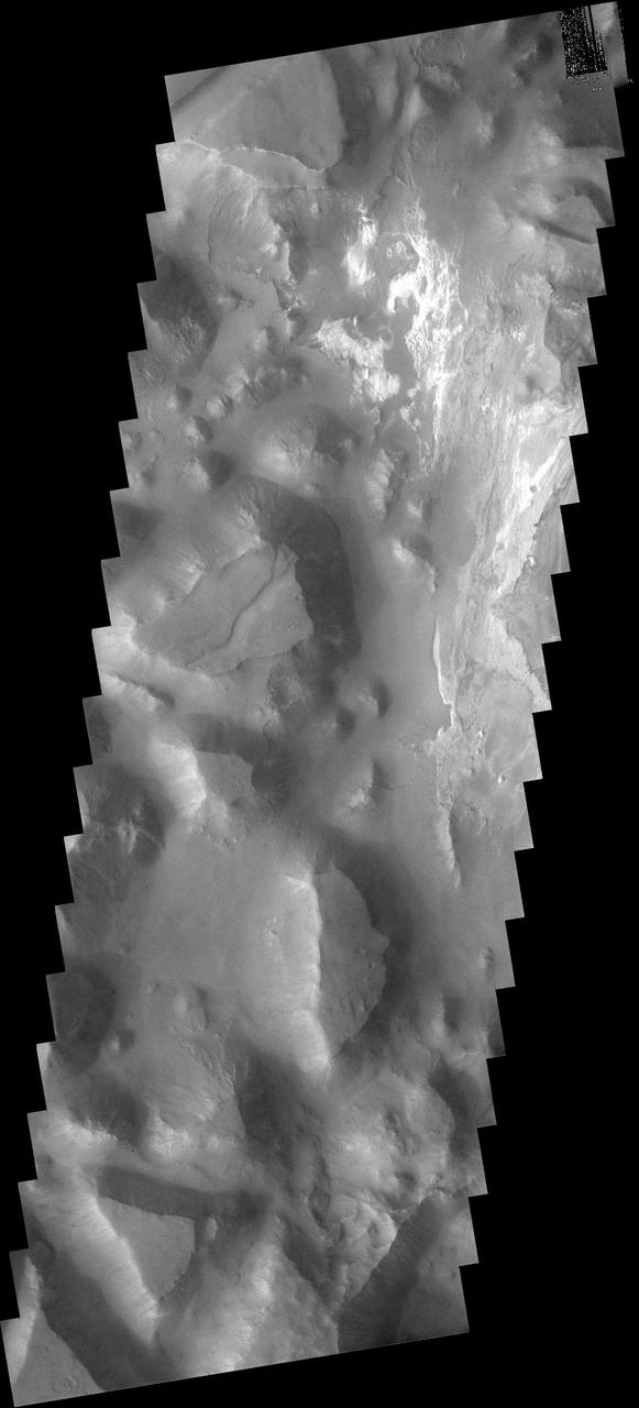 This image captured by NASA 2001 Mars Odyssey spacecraft shows a small portion of Iani Chaos. The brighter floor material is being covered by sand, probably eroded from the mesas of the Chaos.