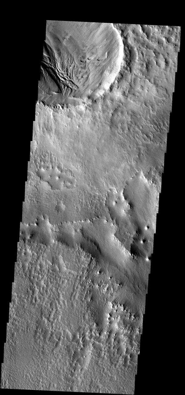 The deposits within this crater show evidence of erosion by both wind and  water. The region outside the crater is dominated by wind erosion