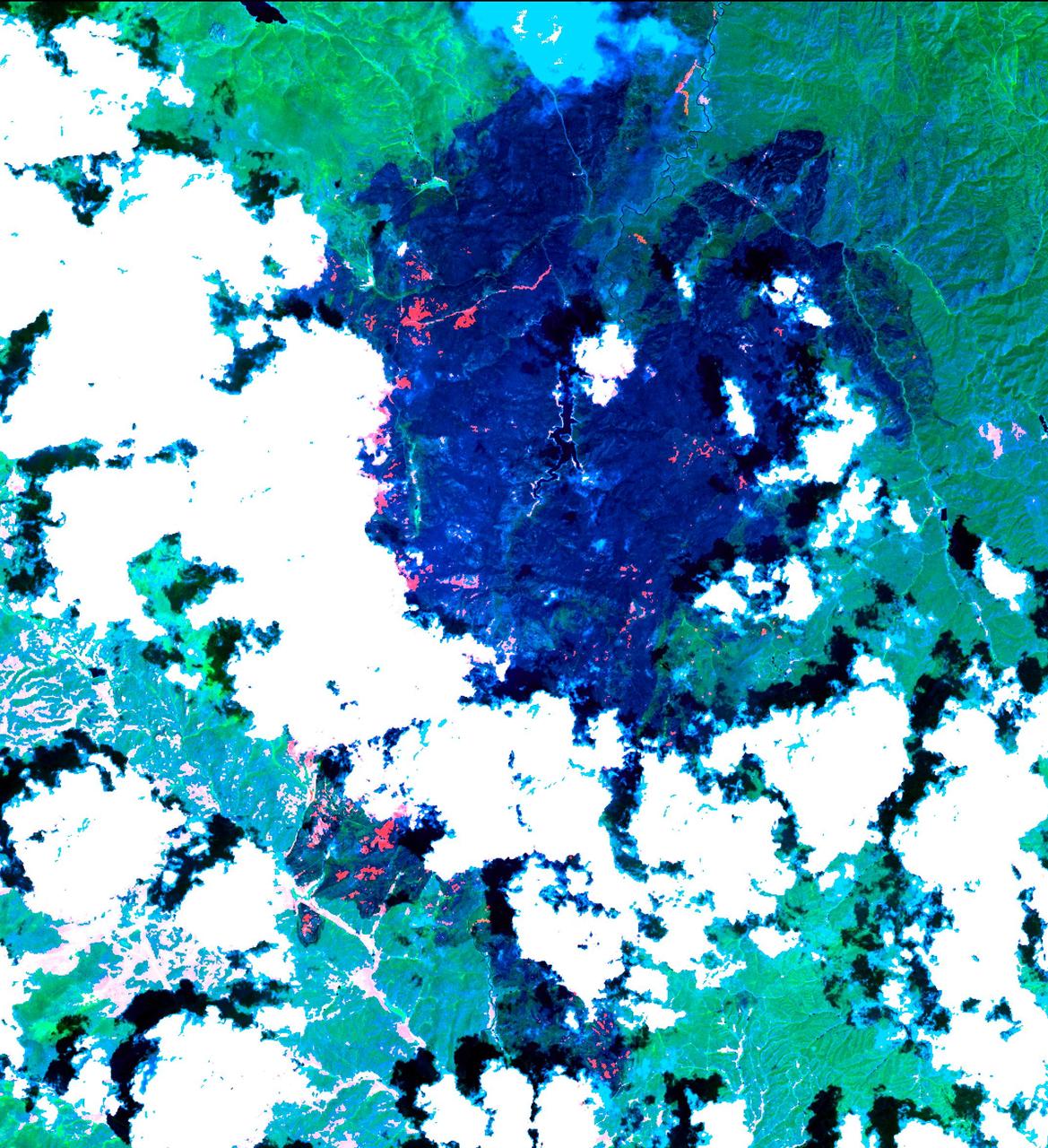 The Hayman forest fire, started on June 8, is continuing to burn in the Pike National Forest, 57 km (35 miles) south-southwest of Denver. According to the U.S. Forest Service, the fire has consumed more than 90,000 acres and has become Colorado's worst fire ever. In this ASTER image, acquired Sunday, June 16, 2002 at 10:30 am MST, the dark blue area is burned vegetation and the green areas are healthy vegetation. Red areas are active fires, and the blue cloud at the top center is smoke. Meteorological clouds are white. The image covers an area of 32.2 x 35.2 km (20.0 x 21.8 miles), and displays ASTER bands 8-3-2 in red, green and blue.  http://photojournal.jpl.nasa.gov/catalog/PIA03499