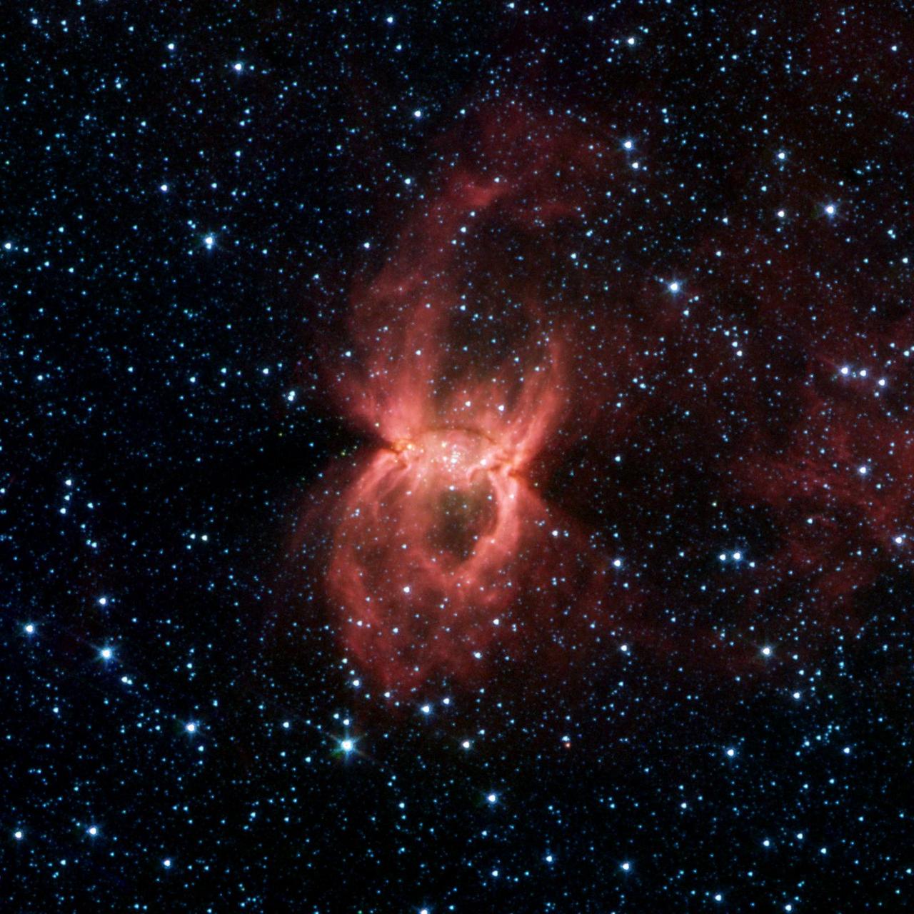 NASA Spitzer Space Telescope shows two opposing bubbles being formed in opposite directions by the powerful outflows from massive groups of forming stars. The baby stars can be seen as specks of yellow where the two bubbles overlap.