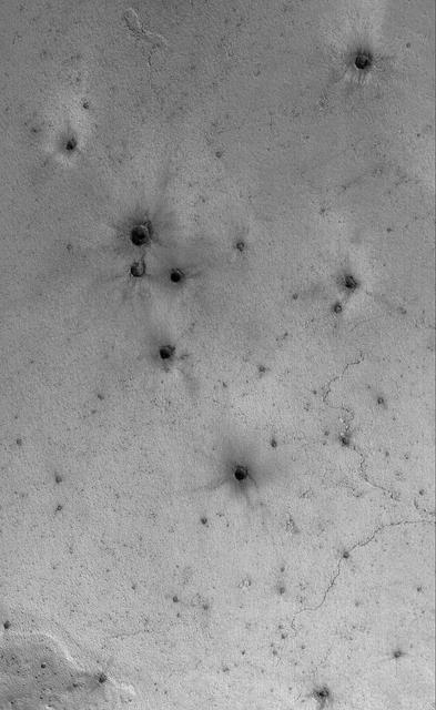 This Mars Global Surveyor MGS Mars Orbiter Camera MOC image shows a field of small craters formed by secondary debris thrown from a larger meteoritic impact on the plains south of the Cerberus region
