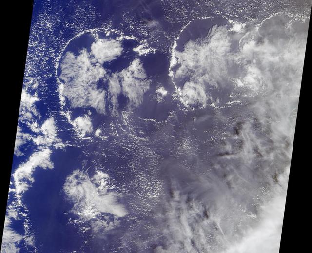 The image was acquired by NASA Terra satellite on March 11, 2002, and is centered west of the Marshall Islands. Enewetak Atoll is discernible through thin cloud as the turquoise band near the right-hand edge of the image.