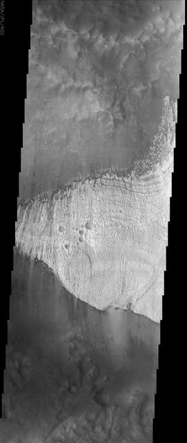 The finely layered deposit in Becquerel crater, seen in the center of this NASA Mars Odyssey image, is slowly being eroded away by the action of windblown sand. 