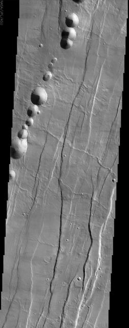 Tantalus Fossae, seen in this image from NASA Mars Odyssey spacecraft, is a set of long valleys on the eastern side of Alba Patera. These valleys are referred to as grabens and are formed by extension of the crust and faulting.