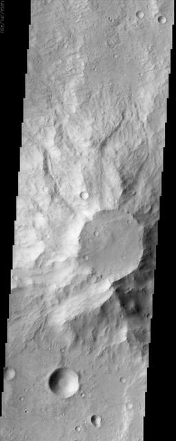 This positive relief feature in the ancient highlands of Mars, imaged by NASA Mars Odyssey spacecraft, appears to be a heavily eroded volcanic center. The top of the feature appears to be under attack by the erosive forces of the Martian wind.