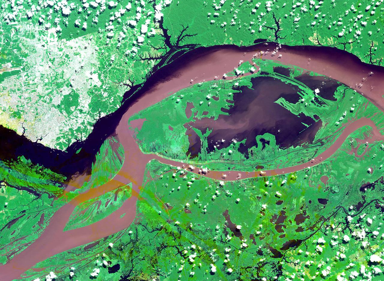 The junctions of the Amazon and the Rio Negro Rivers at Manaus, Brazil. The Rio Negro flows 2300 km from Columbia, and is the dark current forming the north side of the river. It gets its color from the high tannin content in the water. The Amazon is sediment laden, appearing brown in this simulated natural color image. Manaus is the capital of Amazonas state, and has a population in excess of one million. The ASTER image covers an area of 60 x 45 km. This image was acquired on July 16, 2000 by the Advanced Spaceborne Thermal Emission and Reflection Radiometer (ASTER) on NASA's Terra satellite. With its 14 spectral bands from the visible to the thermal infrared wavelength region, and its high spatial resolution of 15 to 90 meters (about 50 to 300 feet), ASTER will image Earth for the next 6 years to map and monitor the changing surface of our planet.  http://photojournal.jpl.nasa.gov/catalog/PIA03851