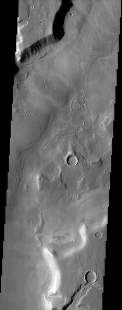 A broad channel in the Deuteronilus Mensae region, shown in this NASA Mars Odyssey image, displays the strange landforms common to the northern mid-latitudes where ground ice likely plays a role in their formation.