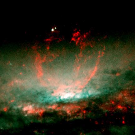 A lumpy bubble of hot gas rises from a cauldron of glowing matter in a distant galaxy, as seen by NASA Hubble Space Telescope.