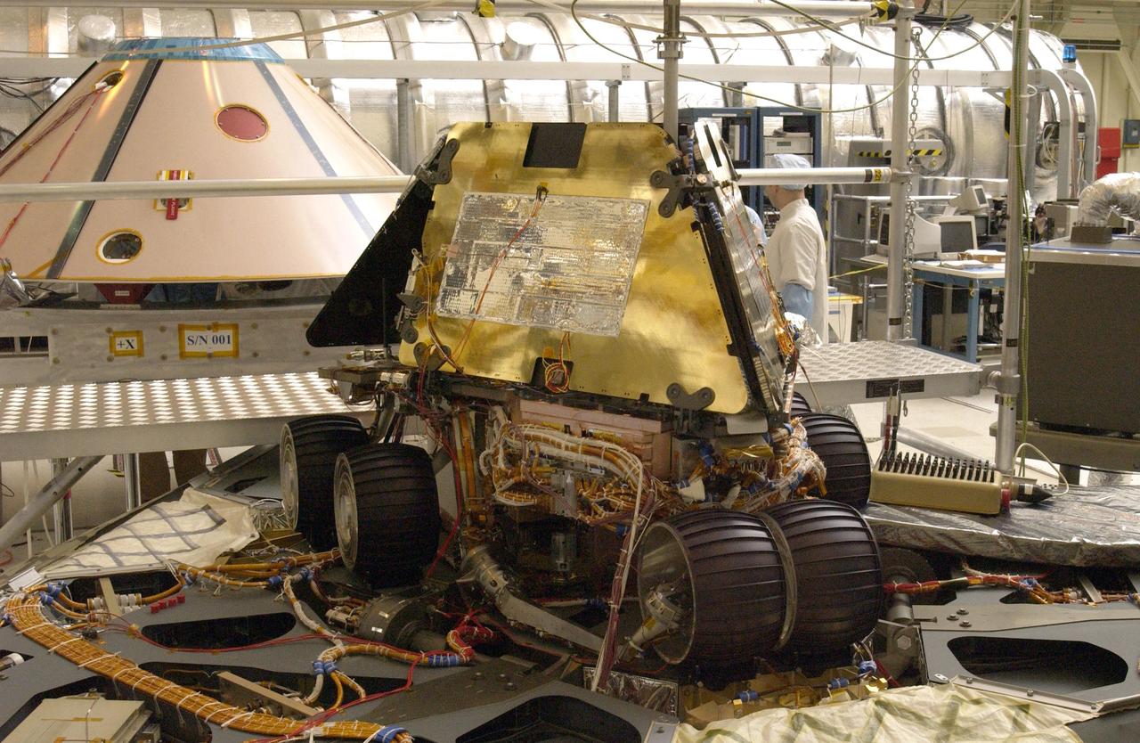 NASA Rover 1 sits atop the deployed lander with its solar arrays and wheels stowed.