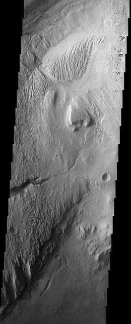 The eroded, layered deposit in this NASA Mars Odyssey image of Gale Crater is a mound of material rising 3 km about 2 miles above the crater floor. It has been sculpted by wind and possibly water to produce the dramatic landforms seen today.