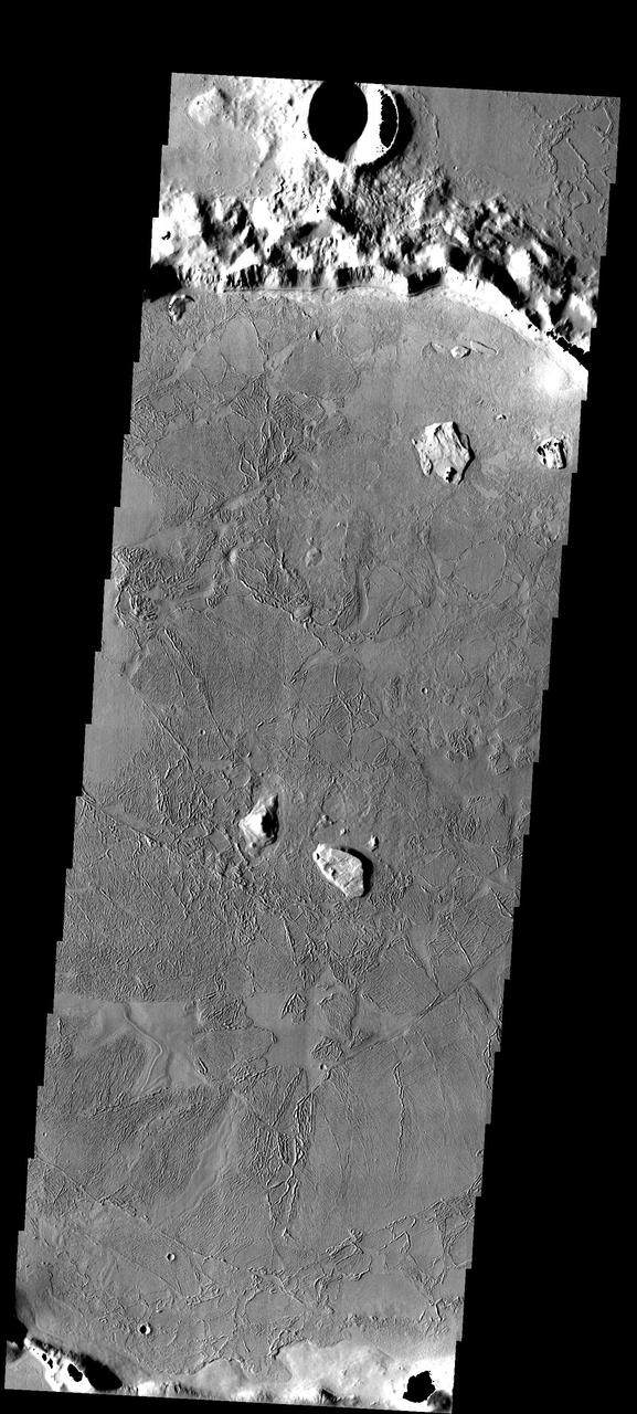 This image from NASA Mars Odyssey spacecraft shows a flooded crater in Amazonis Planitia. This crater has been either flooded with mud and or lava. The fluid then ponded up, dried and formed the surface textures we see today.
