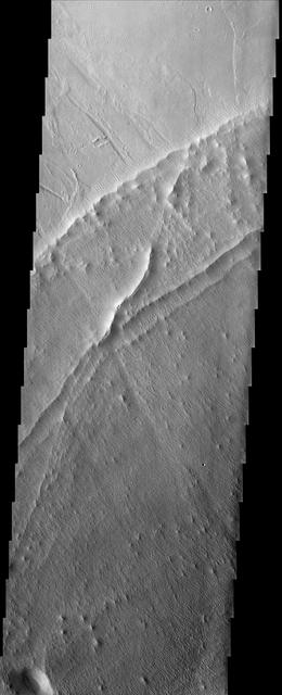 Hummocky, textured terrain within lava flows northwest of Pavonis Mons, one of the Tharsis volcanoes, is shown in this image from NASA Mars Odyssey spacecraft.
