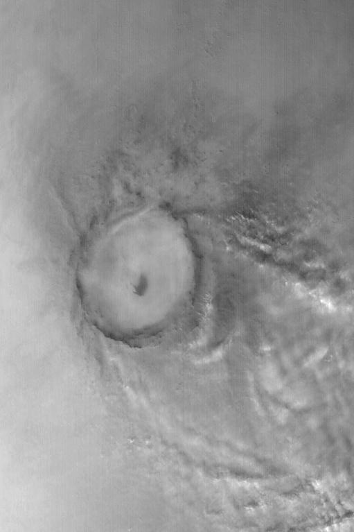 Mie Crater, a large basin formed by asteroid or comet impact in Utopia Planitia, lies at the center of this Mars Global Surveyor (MGS) Mars Orbiter Camera (MOC) red wide angle image. The crater is approximately 104 km (65 mi) across. To the east and southeast (toward the lower right) of Mie, in this 5 December 2003 view, are clouds of dust and water ice kicked up by local dust storm activity. It is mid-winter in the northern hemisphere of Mars, a time when passing storms are common on the northern plains of the red planet. Sunlight illuminates this image from the lower left; Mie Crater is located at 48.5°N, 220.3°W. Viking 2 landed west/southwest of Mie Crater, off the left edge of this image, in September 1976.   http://photojournal.jpl.nasa.gov/catalog/PIA04930
