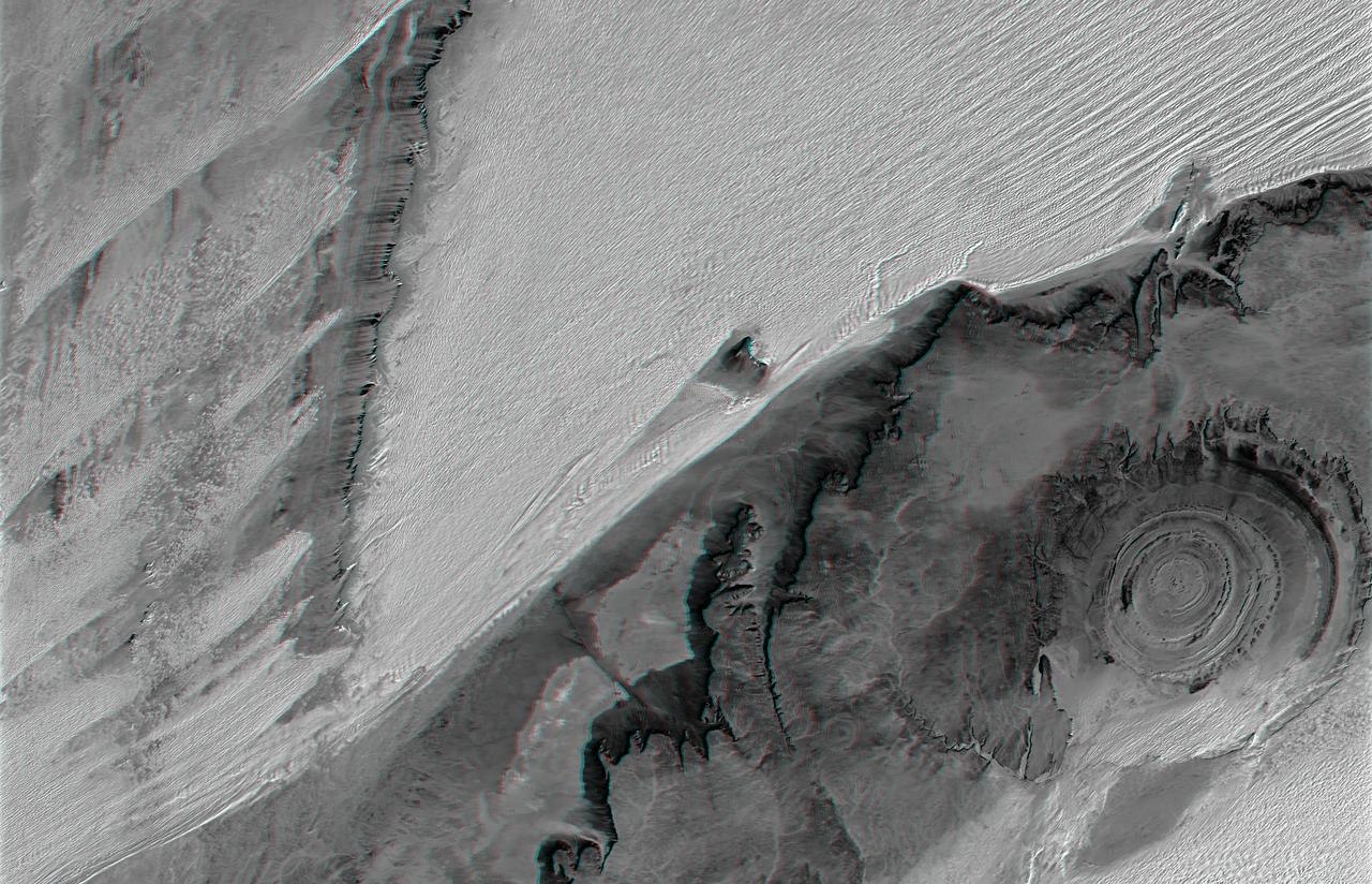 The prominent circular feature seen here is known as the Richat Structure, in the Sahara desert of Mauritania. This anaglyph is from NASA Shuttle Radar Topography Mission. 3D glasses are necessary to view this image.