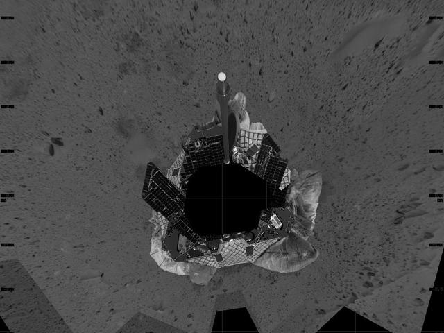 This mosaic image taken by the navigation camera on the Mars Exploration Rover Spirit represents an overhead view of the rover as it prepares to roll off the lander and onto the martian surface. The yellow arrow illustrates the direction the rover may take to roll safely off the lander. The rover was originally positioned to roll straight forward off the lander (south side of image). However, an airbag is blocking its path. To take this northeastern route, the rover must back up and perform what is likened to a 3-point turn in a cramped parking lot. http://photojournal.jpl.nasa.gov/catalog/PIA05044