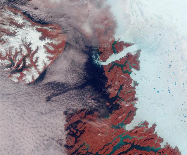 Vibrant reds, emerald greens, brilliant whites, and pastel blues adorn this view of the area surrounding the Jakobshavn Glacier on the western coast of Greenland captured by NASA Terra spacecraft on June 18, 2003.