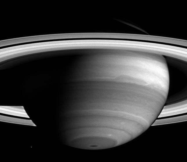 As Cassini nears its rendezvous with Saturn, new detail in the banded clouds of the planet's atmosphere are becoming visible.  Cassini began the journey to the ringed world of Saturn nearly seven years ago and is now less than two months away from orbit insertion on June 30. Cassini’s narrow-angle camera took this image on April 16, 2004, when the spacecraft was 38.5 million kilometers (23.9 million miles) from Saturn.  Dark regions are generally areas free of high clouds, and bright areas are places with high, thick clouds which shield the view of the darker areas below. A dark spot is visible at the south pole, which is remarkable to scientists because it is so small and centered. The spot could be affected by Saturn's magnetic field, which is nearly aligned with the planet's rotation axis, unlike the magnetic fields of Jupiter and Earth. From south to north, other notable features are the two white spots just above the dark spot toward the right, and the large dark oblong-shaped feature that extends across the middle. The darker band beneath the oblong-shaped feature has begun to show a lacy pattern of lighter-colored, high altitude clouds, indicative of turbulent atmospheric conditions.  The cloud bands move at different speeds, and their irregularities may be due to either the different motions between them or to disturbances below the visible cloud layer. Such disturbances might be powered by the planet's internal heat; Saturn radiates more energy than it receives from the Sun.  The moon Mimas (396 kilometers, 245 miles across) is visible to the left of the south pole. Saturn currently has 31 known moons. Since launch, 13 new moons have been discovered by ground-based telescopes. Cassini will get a closer look and may discover new moons, perhaps embedded within the planet’s magnificent rings.  This image was taken using a filter sensitive to light near 727 nanometers, one of the near-infrared absorption bands of methane gas, which is one of the ingredients in Saturn's atmosphere. The image scale is approximately 231 kilometers (144 miles) per pixel. Contrast has been enhanced to aid visibility of features in the atmosphere.  http://photojournal.jpl.nasa.gov/catalog/PIA05391