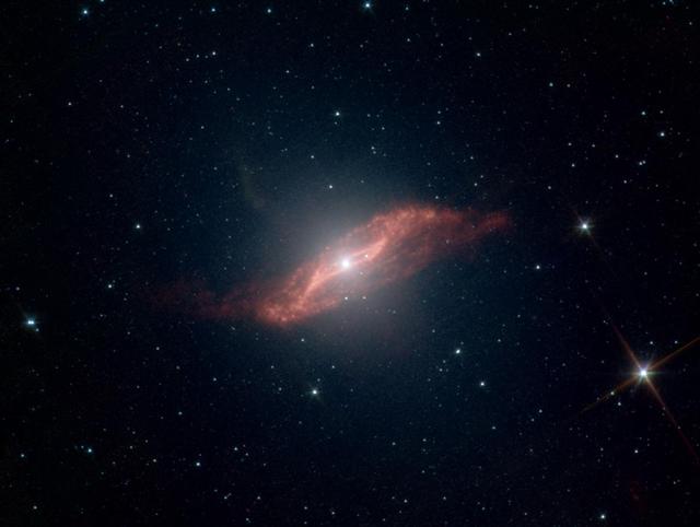 This image taken by NASA Spitzer Space Telescope shows in unprecedented detail the galaxy Centaurus A last big meal: a spiral galaxy seemingly twisted into a parallelogram-shaped structure of dust. 