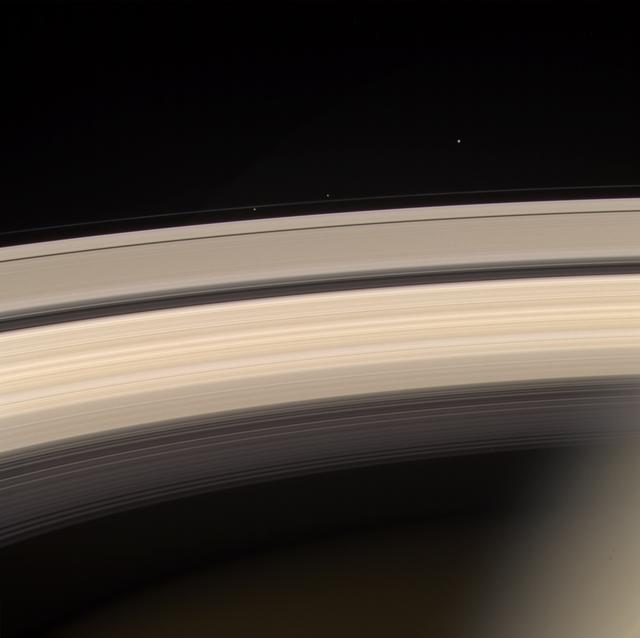 Saturn and its rings are prominently shown in this color image, along with three of Saturn's smaller moons. From left to right, they are Prometheus, Pandora and Janus. Prometheus and Pandora are often called the "F ring shepherds" as they control and interact with Saturn's interesting F ring, seen between them. This image was taken on June 18, 2004, with the Cassini spacecraft narrow angle camera 8.2 million kilometers (5.1 million miles) from Saturn. It was created using the red, green, and blue filters. Contrast has been enhanced to aid visibility. http://photojournal.jpl.nasa.gov/catalog/PIA06422