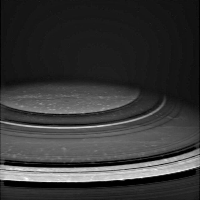 Atmospheric features in Saturn's north polar region are revealed in spectacular detail in this Cassini image, taken in the near infrared spectral region, where methane gas is not very absorbing. The dark shadows of Saturn's rings drape across the planet, creating the illusion of atmospheric bands. Dots of bright clouds give the appearance that this is an active place.  The image was taken with the Cassini spacecraft wide angle camera on Dec. 14, 2004, at a distance of 717,800 kilometers (446,100 miles) from Saturn through a filter sensitive to wavelengths of infrared light centered at 939 nanometers. The image scale is about 43 kilometers (27 miles) per pixel.  http://photojournal.jpl.nasa.gov/catalog/PIA06567