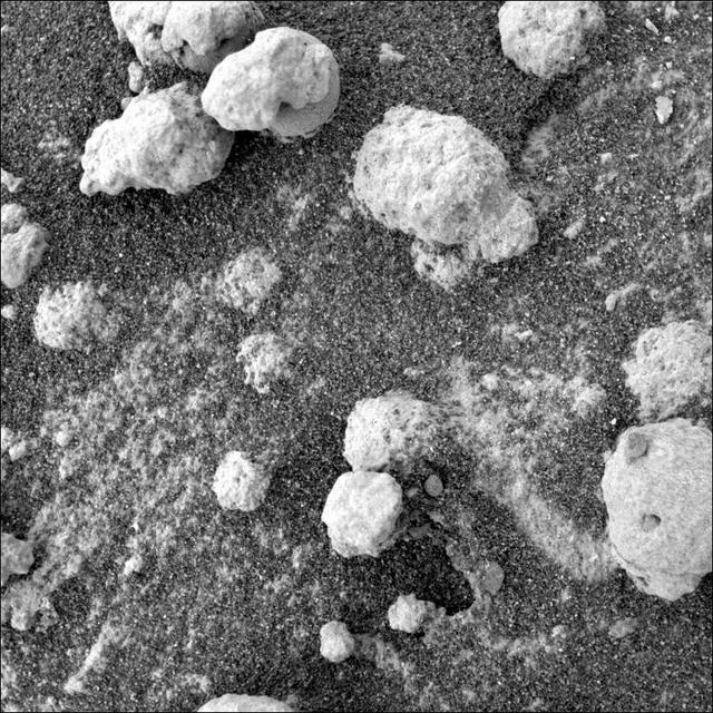 This view from the microscopic imager on NASA Mars Exploration Rover Opportunity shows a type of light-colored, rough-textured spherules scientists call popcorn in contrast to the darker, smoother spherules called blueberries.