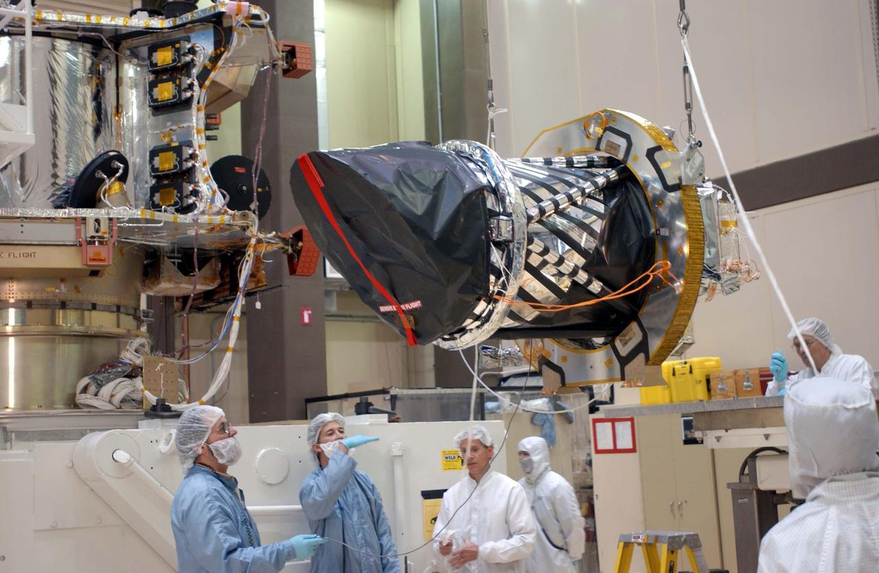 Workers at Lockheed Martin Space Systems, Denver, hoist a telescopic camera for installation onto NASA Mars Reconnaissance Orbiter spacecraft on Dec. 11, 2004.