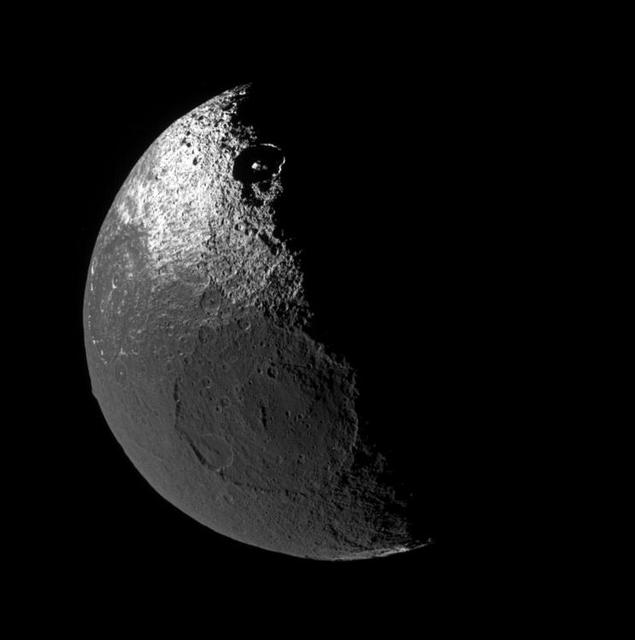Although it is no longer uncharted land, the origin of the dark territory  of Cassini Regio on Iapetus remains a mystery. The view looks down onto the northern hemisphere of Iapetus and shows terrain on the moon leading  hemisphere