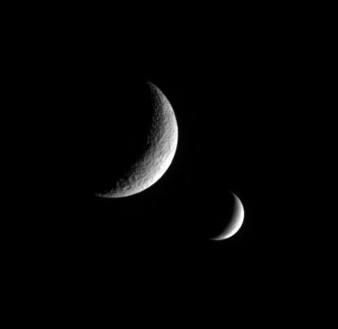 NASACassini spacecraft captures this dual portrait of an apparently dead moon and one that is very much alive. Tethys, shows no signs of recent  geologic activity. Enceladus, however, is covered in fractures and faults  and spews icy particles into space