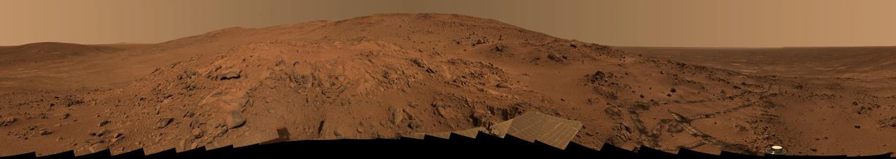 This is the Spirit panoramic camera's "Lookout" panorama, acquired on the rover's 410th to 413th martian days, or sols (Feb. 27 to Mar. 2, 2005). The view is from a position known informally as "Larry's Lookout" along the drive up "Husband Hill." The summit of Husband Hill is the far peak near the center of this panorama and is about 200 meters (656 feet) away from the rover and about 45 meters (148 feet) higher in elevation. The bright rocky outcrop near the center of the panorama is part of the "Cumberland Ridge," and beyond that and to the left is the "Tennessee Valley."  The panorama spans 360 degrees and consists of images obtained in 108 individual pointings and five filters at each pointing. This mosaic is an approximately true-color rendering generated using the images acquired through panoramic camera's 750-nanometer, 530-nanometer, and 480-nanometer filters. The lighting varied considerably during the four sols that it took to acquire this image (partly because of imaging at different times of sol, but also partly because of small sol-to-sol variations in the dustiness of the atmosphere), resulting in some obvious image seams or rock shadow variations within the mosaic. These seams have been smoothed out from the sky parts of the mosaic in order to simulate better the vista that a person would have if they were viewing it all at the same time on Mars. However, it is often not possible or practical to smooth out such seams for regions of rock, soil, rover tracks, or solar panels. Such is the nature of acquiring and assembling large Pancam panoramas from the rovers.  Spirit's tracks leading back from the "West Spur" region can be seen on the right side of the panorama. The region just beyond the area where the tracks made their last zig-zag is the area known as "Paso Robles," where Spirit discovered rock and soil deposits with very high sulfur abundances. After acquiring this mosaic (which took several weeks to fully downlink and then several more weeks to process), Spirit drove around the Cumberland Ridge rocks seen here and is now driving up the flank of Husband Hill, heading toward the summit.  http://photojournal.jpl.nasa.gov/catalog/PIA07882