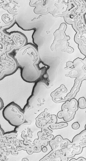 This image shows large, relatively flat-lying, puzzle-like pieces in this scene are mesas composed largely of solid carbon dioxide