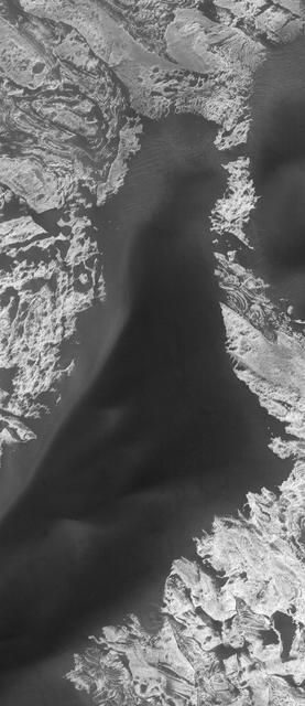 This MOC image shows dark sand dunes superposed on layered, light-toned outcrops -- interpreted to be sedimentary rocks -- in Melas Chasma. Melas Chasma is part of the enormous Valles Marineris trough system