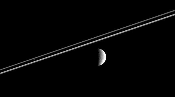 Distant Rhea right poses here for the Cassini spacecraft, as Pandora  hovers against Saturn dark shadow on the rings