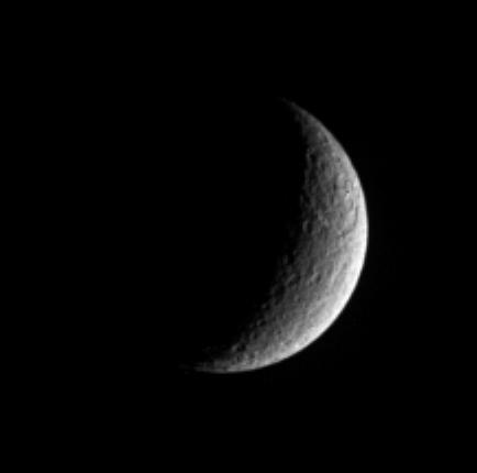 Rhea displays a prominent scar in this view from Cassini. A large and  ancient impact basin can be seen at upper right. The giant feature occurs  within a terrain that appears rugged and which likely is saturated with  other smaller craters