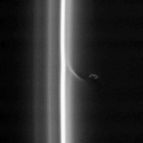 This view shows Prometheus with a streamer it has created in the inner edge of the F ring. Prometheus comes close to the inner edge of the ring once per orbit, perturbing the ring particles there