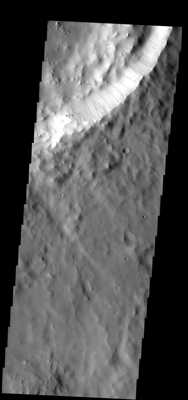 These dark streaks show where dust has been moving down the rim of the unnamed crater