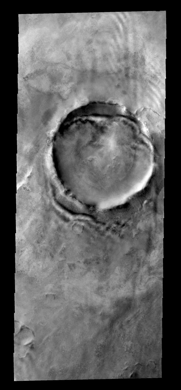 Faint clouds can be seen to the northeast of this crater. The bright and  dark bands against the NE crater rim interior and exterior are bright  clouds and their shadows