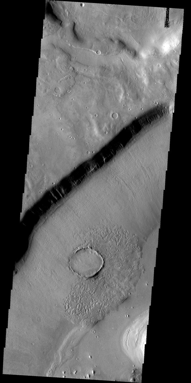 This crater appears to be in the process of being covered over by downslope movement of material. These large slopes of material are common in Deuteronilus Mensae