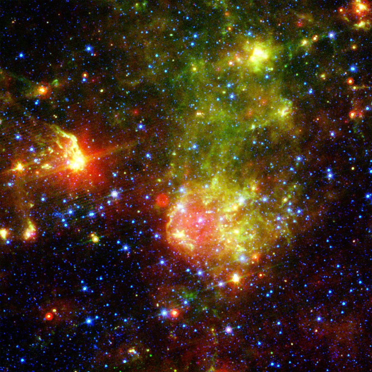 NASA Spitzer Space Telescope shows the supernova remnant 1E0102.2-7219 sits next to the nebula N76 in a bright, star-forming region of the Small Magellanic Cloud, a satellite galaxy to our Milky Way galaxy.