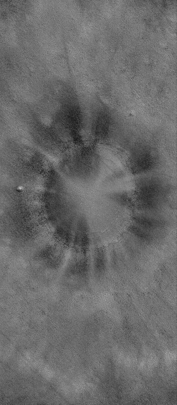 This MOC image shows a bowl-shaped crater on the martian northern plains with a mysterious radiant pattern of zones with and without boulders and rocks