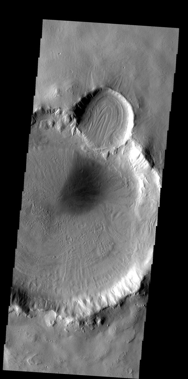 The patterns on the floor of these craters indicates that a volitile, such as ice, likely was present in the floor material