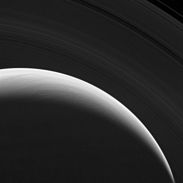 NASA Cassini spacecraft gazes down at the marvelous rings and swirling clouds of giant Saturn from above the planet north pole.