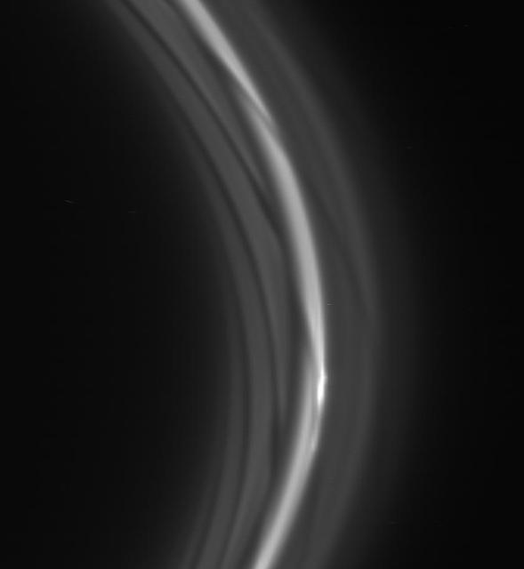 The striated appearance of the F ring is immediately apparent in the region of the ring that trails behind the moon Prometheus