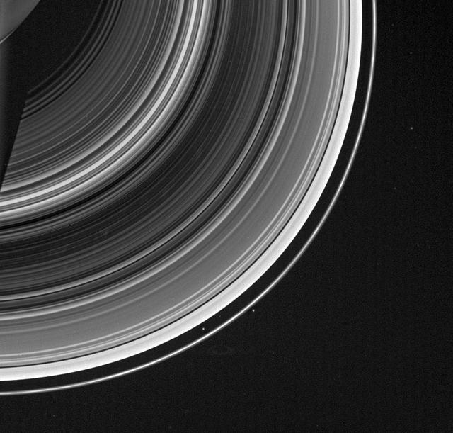 From on high, the Cassini spacecraft spots a group of faint spokes against the striped landscape of the B ring, the dark region in the middle of the rings here. The spokes appear as irregular blotches