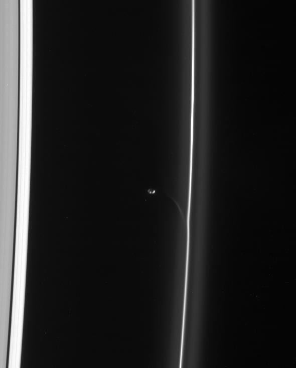 Prometheus draws a fresh streamer of material from the F ring as it passes the ring interior edge. The streamer will continuously shear out as it orbits the planet, becoming more elongated and increasingly aligned with the F ring with time