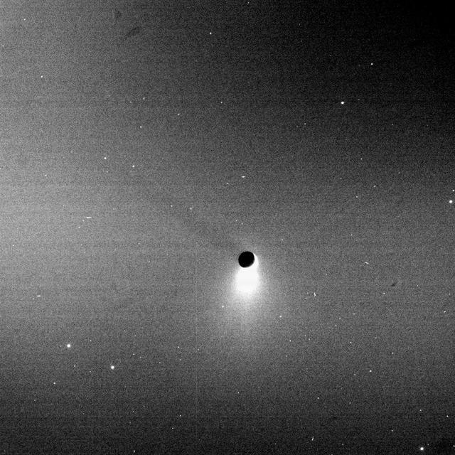 Blazing like an icy torch, the plume of Enceladus shines in scattered sunlight as the moon casts a shadow onto Saturn E ring