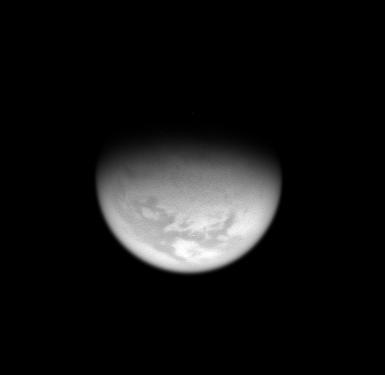 From high above Titan northern hemisphere, the Cassini spacecraft takes an oblique view toward the mid-latitude dark regions that gird the giant moon