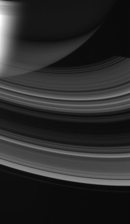 The rings of Saturn glow softly as sunlight from below wends its way through. Some of the Sun light bounces off the rings opposite side