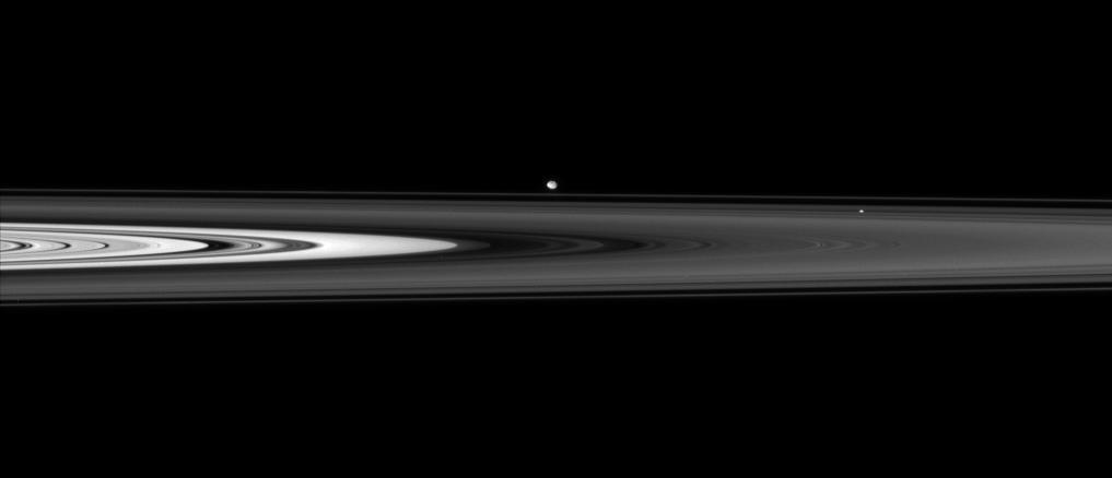 The Cassini spacecraft skims past Saturn ringplane at a low angle, spotting two ring moons on the far side